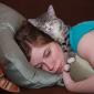 Julia Miller lying on the couch while Sasha sleeps on top of her.