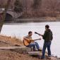 Two guitar players around Lake of the Isles.