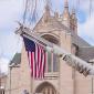 A flag hangs from a cherry picker in front of the House of Hope Presbyterian Church on Summit Avenue
